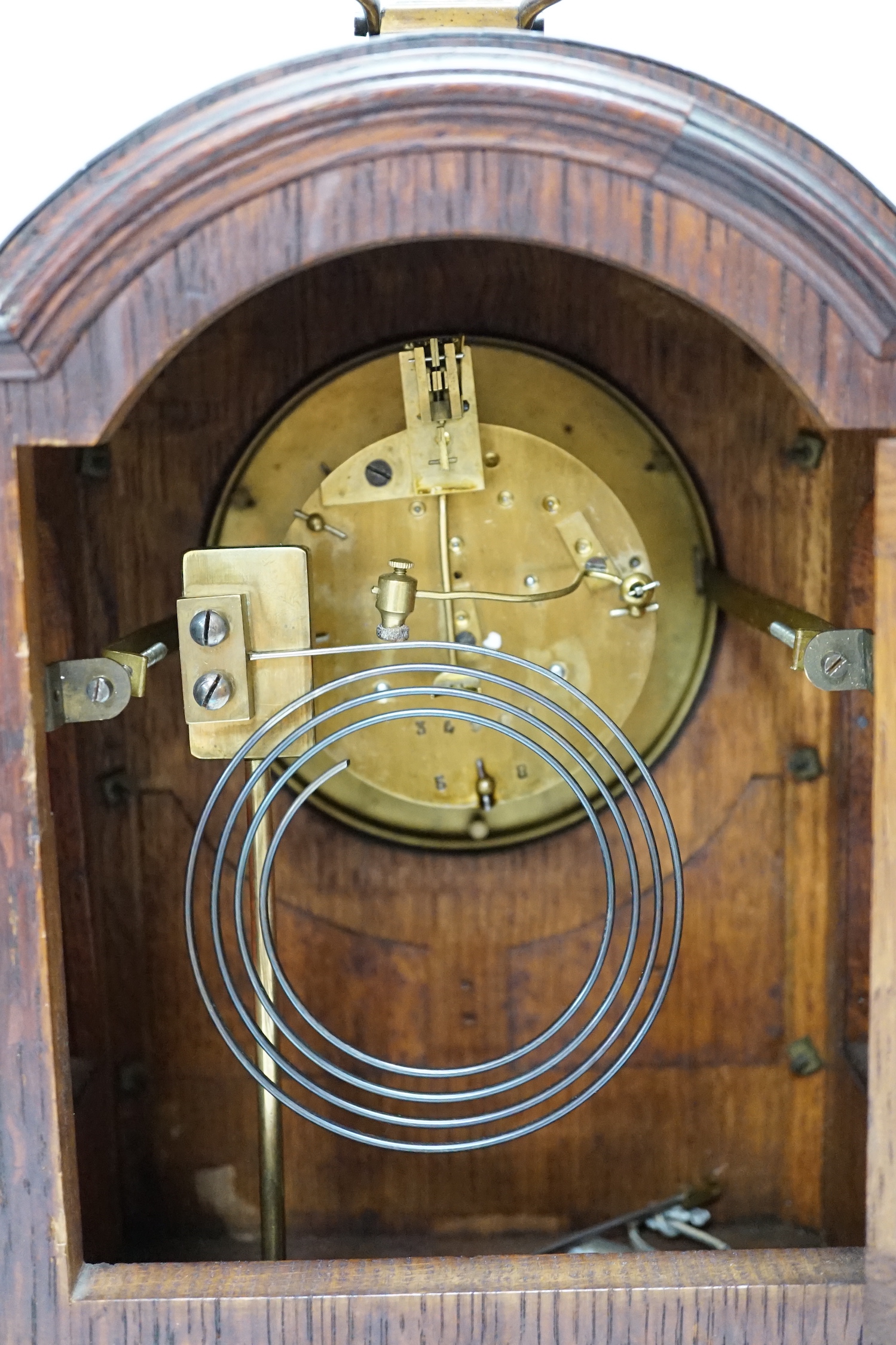 A oak mantel clock in a Regency style with pad top, striking on a coiled gong, 30cm high